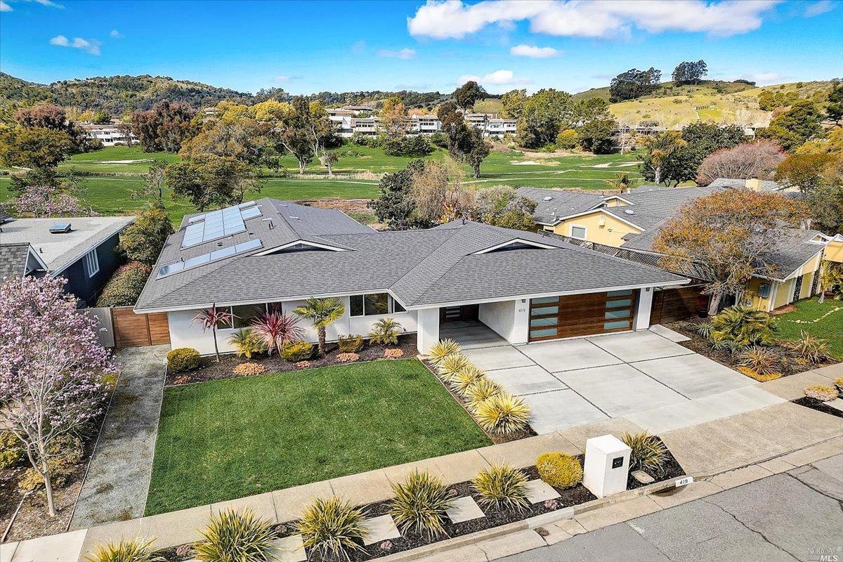 an aerial view of a house with garden space and street view