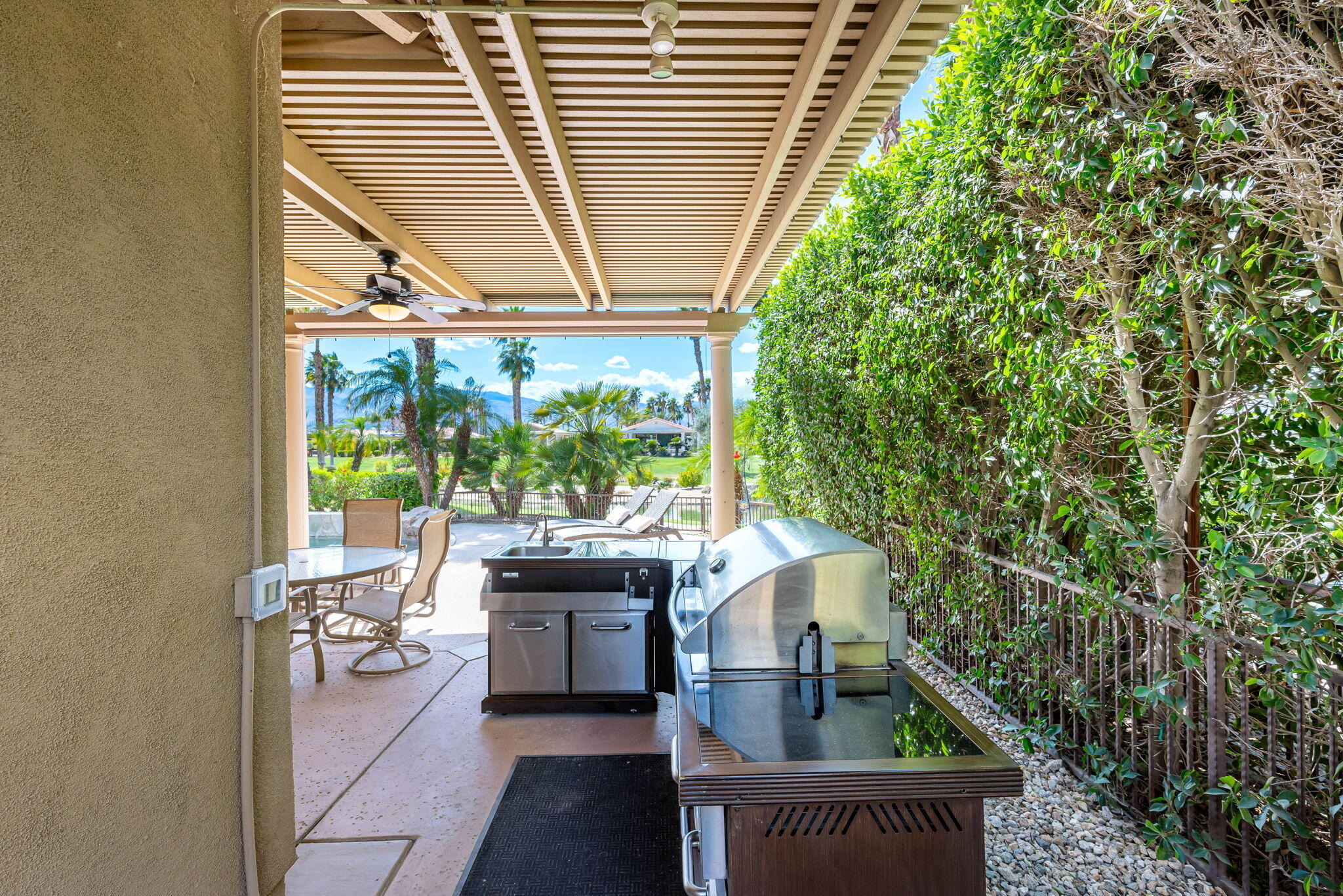 48170 Hjorth Street, Unit 74 Indio, CA 92201 - Photo 12 of 37 a front view of a house with outdoor seating and trees in the background