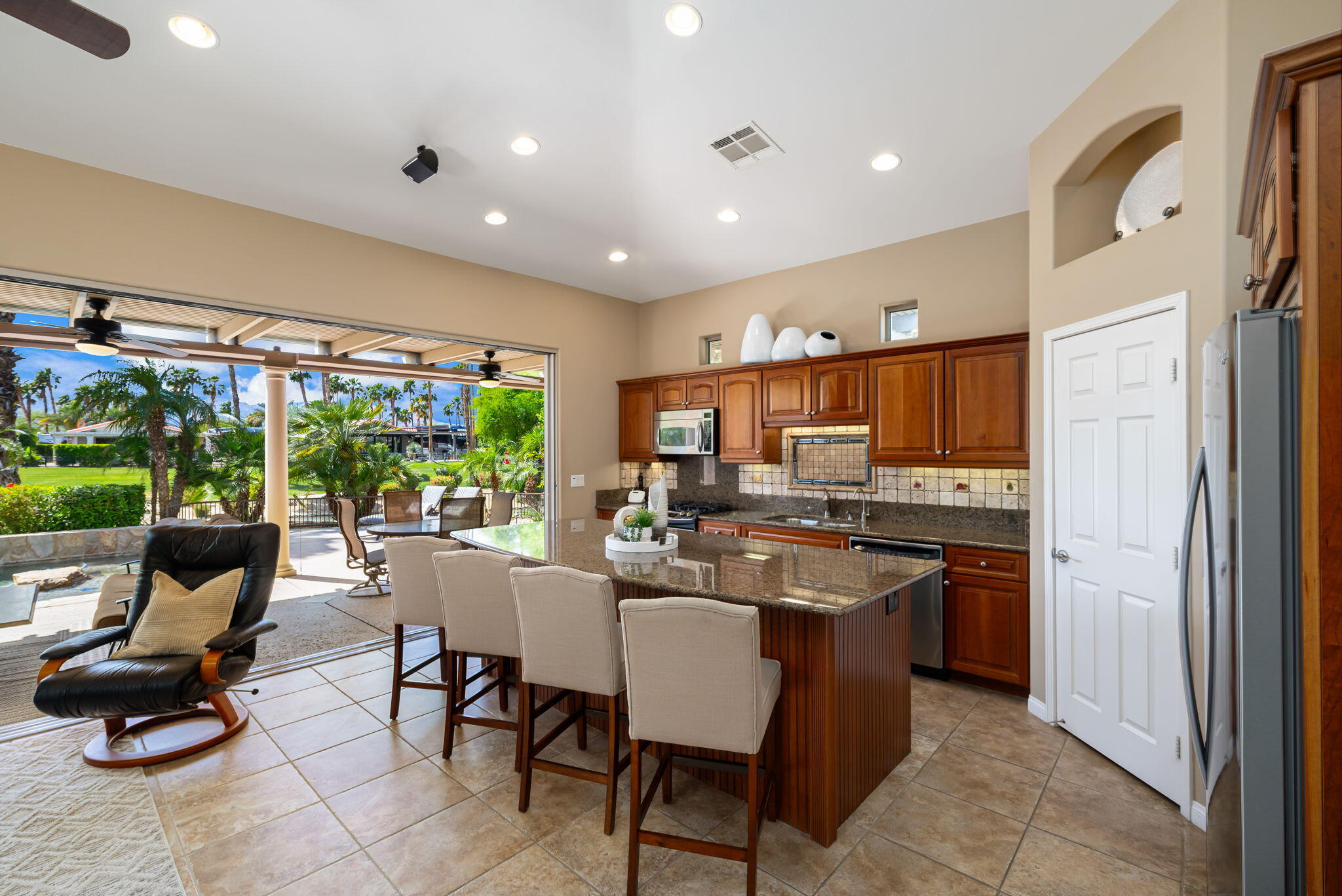 48170 Hjorth Street, Unit 74 Indio, CA 92201 - Photo 27 of 37 a kitchen with stainless steel appliances granite countertop sink stove dining table and chairs