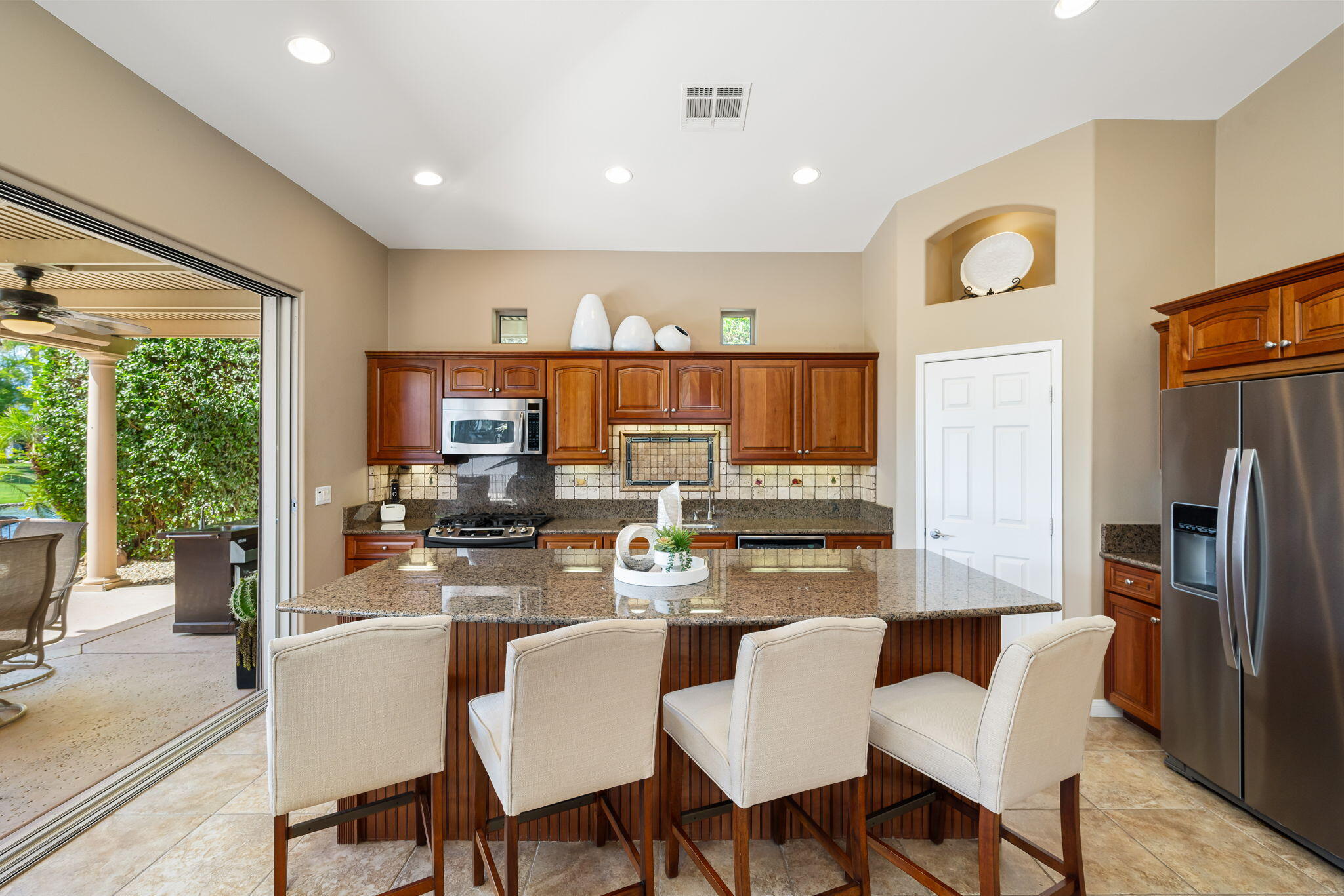 48170 Hjorth Street, Unit 74 Indio, CA 92201 - Photo 28 of 37 a kitchen with stainless steel appliances granite countertop a table chairs and a refrigerator