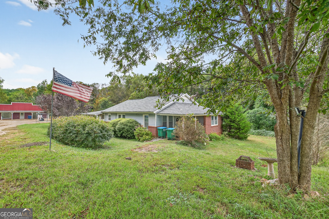 a view of a house with a yard and tree s