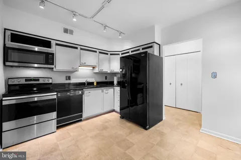 a kitchen with granite countertop a refrigerator and a stove