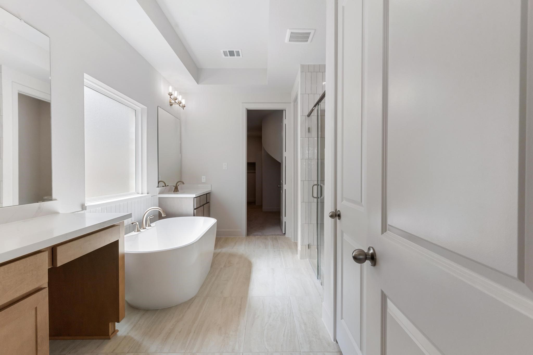 407 Mathis Lk Court Conroe, TX 77304 - Photo 8 of 26 Primary bathroom with standalone tub, oversized shower and separate vanities.
