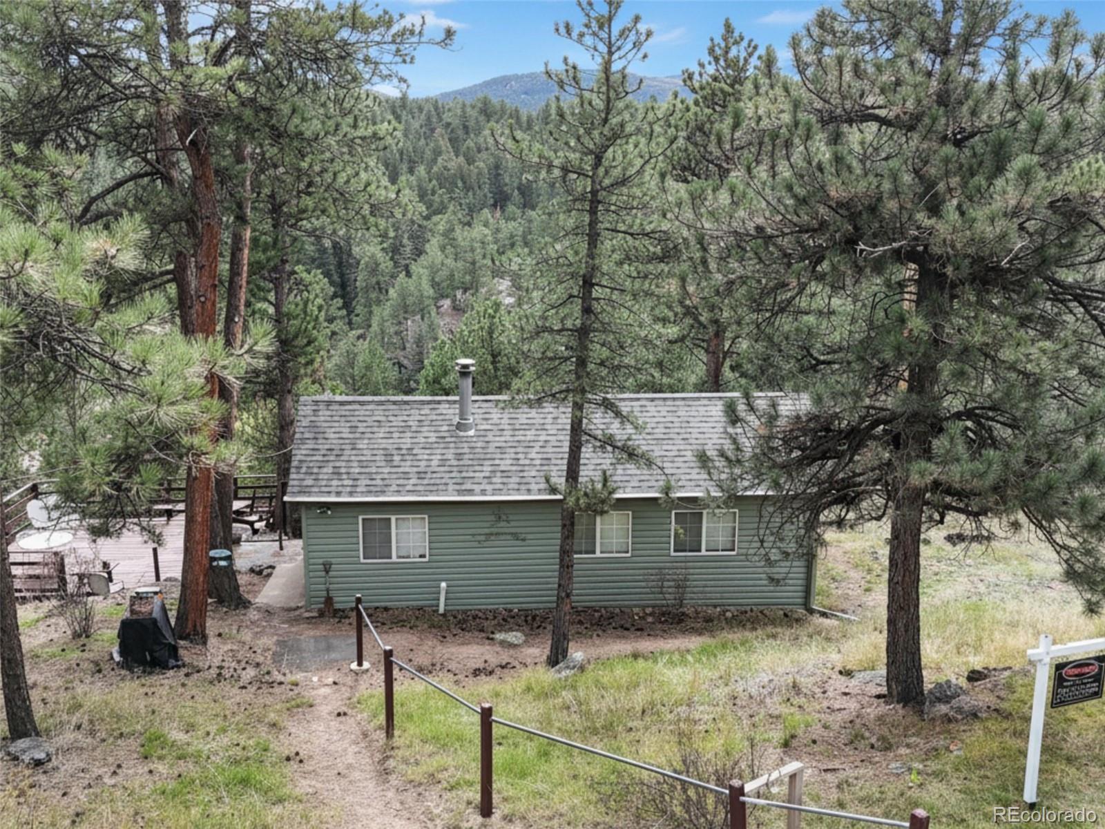 5162 South Rd A Evergreen, CO 80439 - Photo 23 of 26 a view of a house with large tree next to a yard