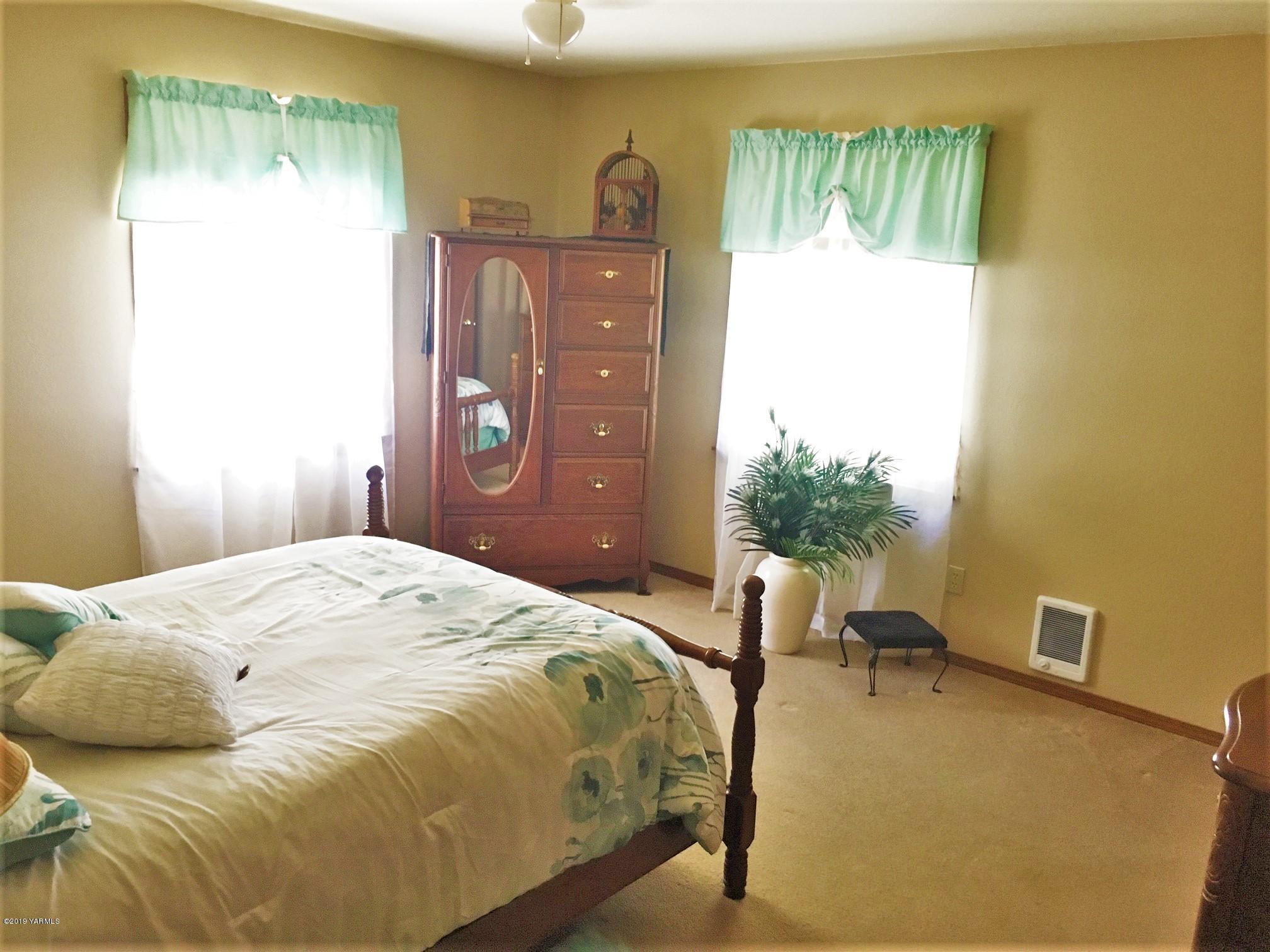 2060 Liberty Road Granger, WA 98932 - Photo 19 of 25 a bedroom with a bed and a table in it