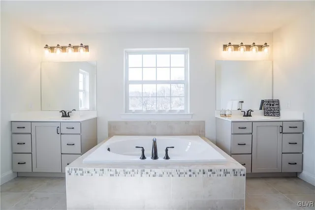 a spacious bathroom with a tub sink and mirror