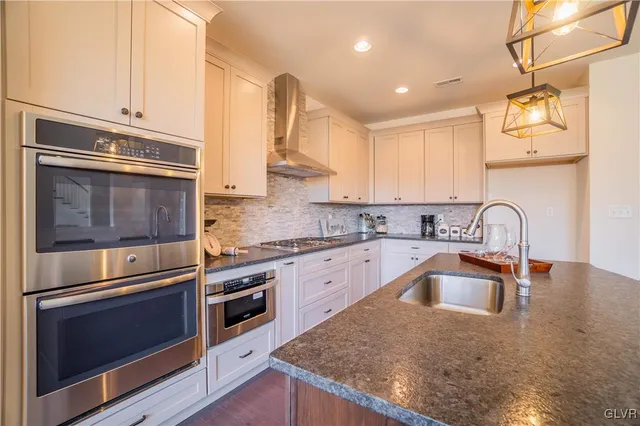a kitchen with granite countertop stainless steel appliances and stove top oven