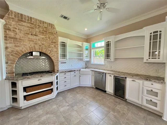 a kitchen with granite countertop a stove sink and cabinets
