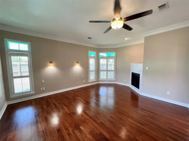 a view of an empty room with window and wooden floor