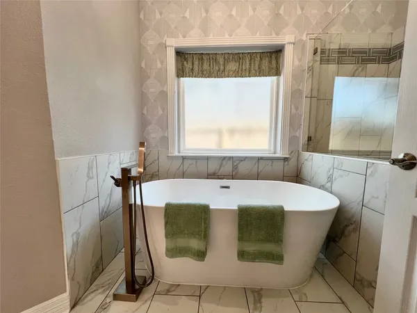 a bath tub sitting in a bathroom next to a window