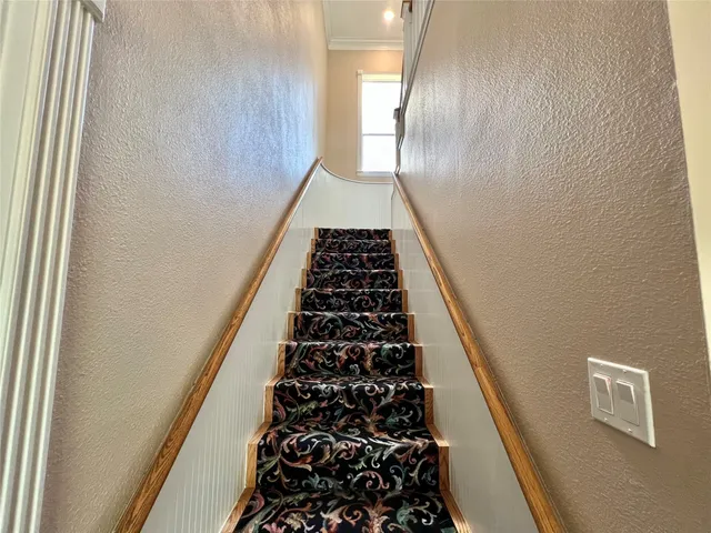a view of an empty room with wooden floor and windows
