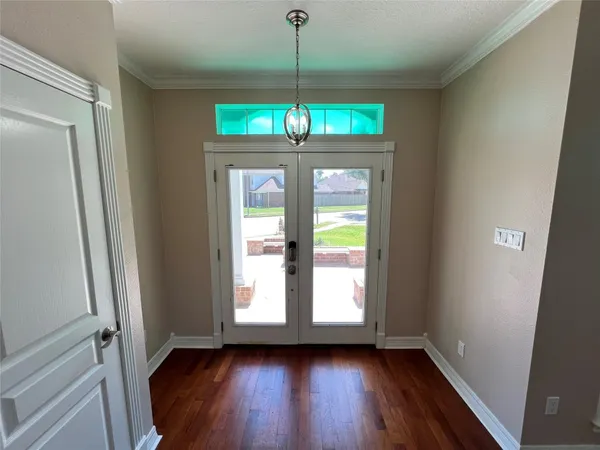 a view of a room with wooden floor and chandelier