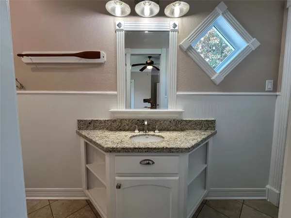 a bathroom with a granite countertop sink and a mirror