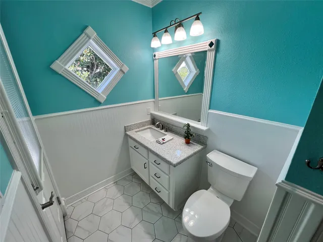 a bathroom with a granite countertop shower and a toilet