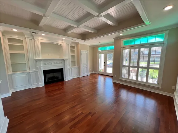 a view of empty room with wooden floor and fireplace