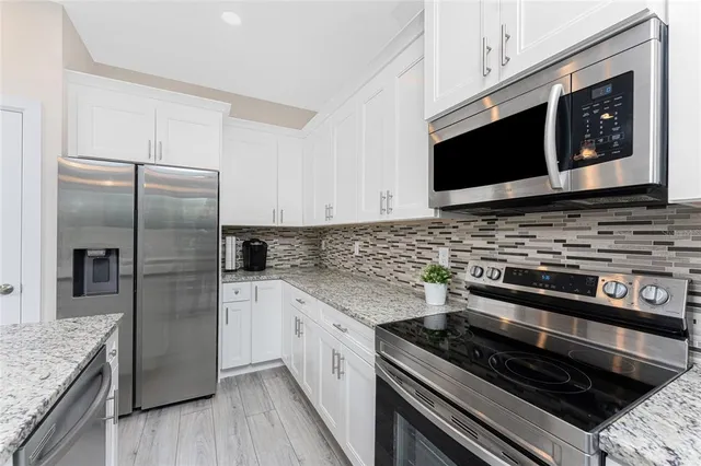 a kitchen with stainless steel appliances granite countertop a stove microwave and sink