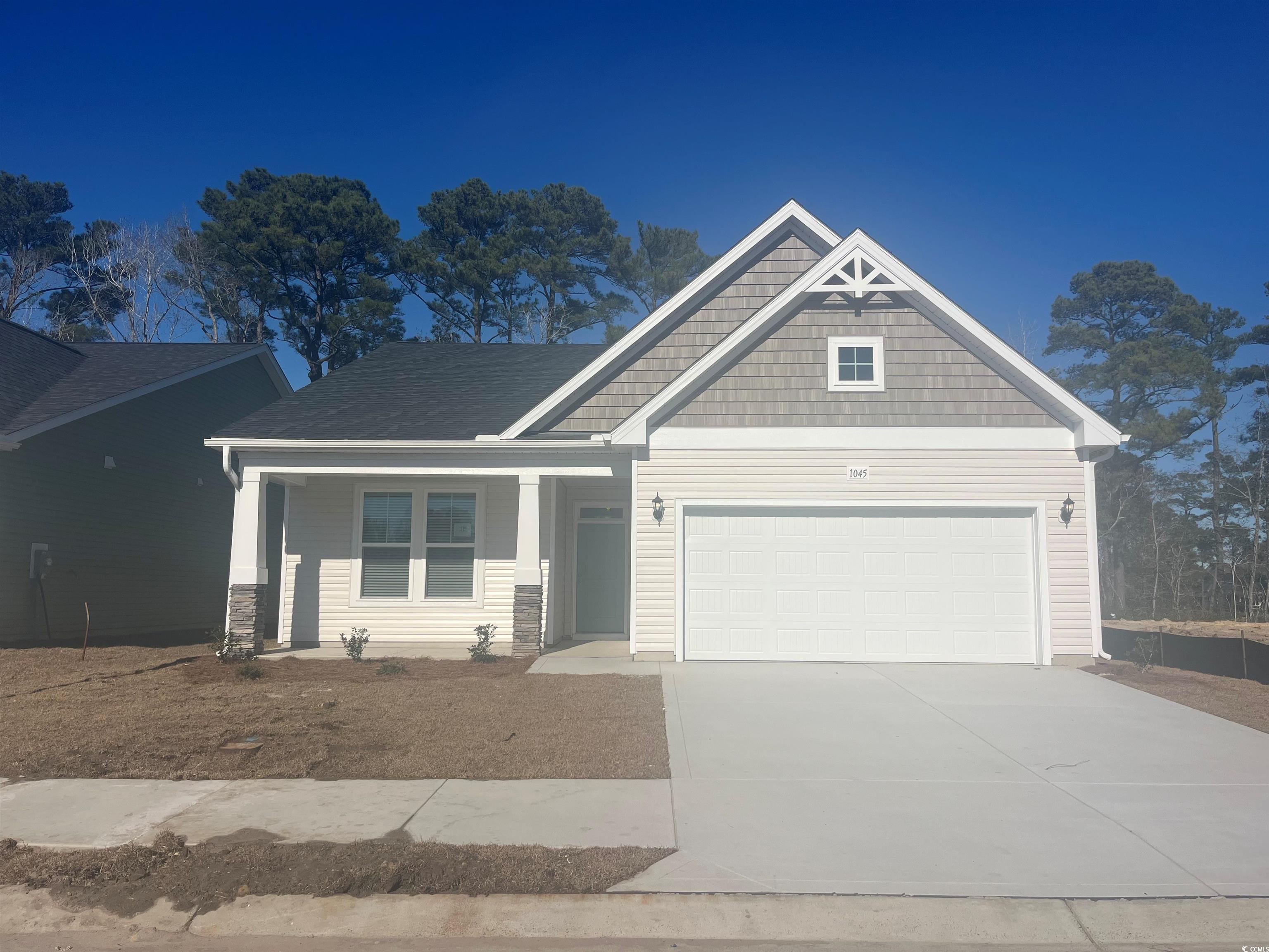 Craftsman inspired home featuring a porch, concrete driveway, and a garage