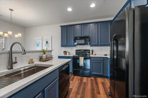a kitchen with granite countertop a refrigerator and a sink