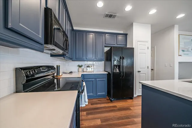 a kitchen with a refrigerator stove and wooden cabinets