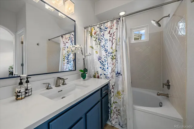 a bathroom with a sink double vanity mirror and a bathtub