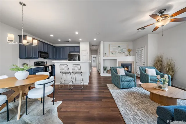 a living room with furniture a kitchen island with furniture and wooden floor