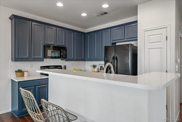 a kitchen with stainless steel appliances granite countertop a refrigerator stove a sink dishwasher and microwave with wooden cabinets