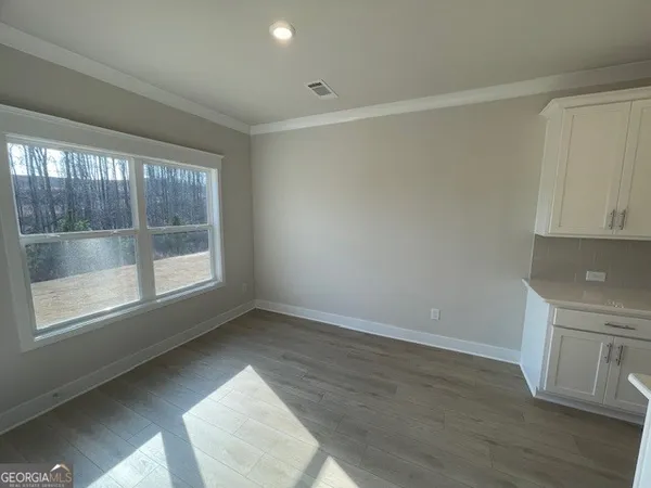an empty room with windows and ceiling fan