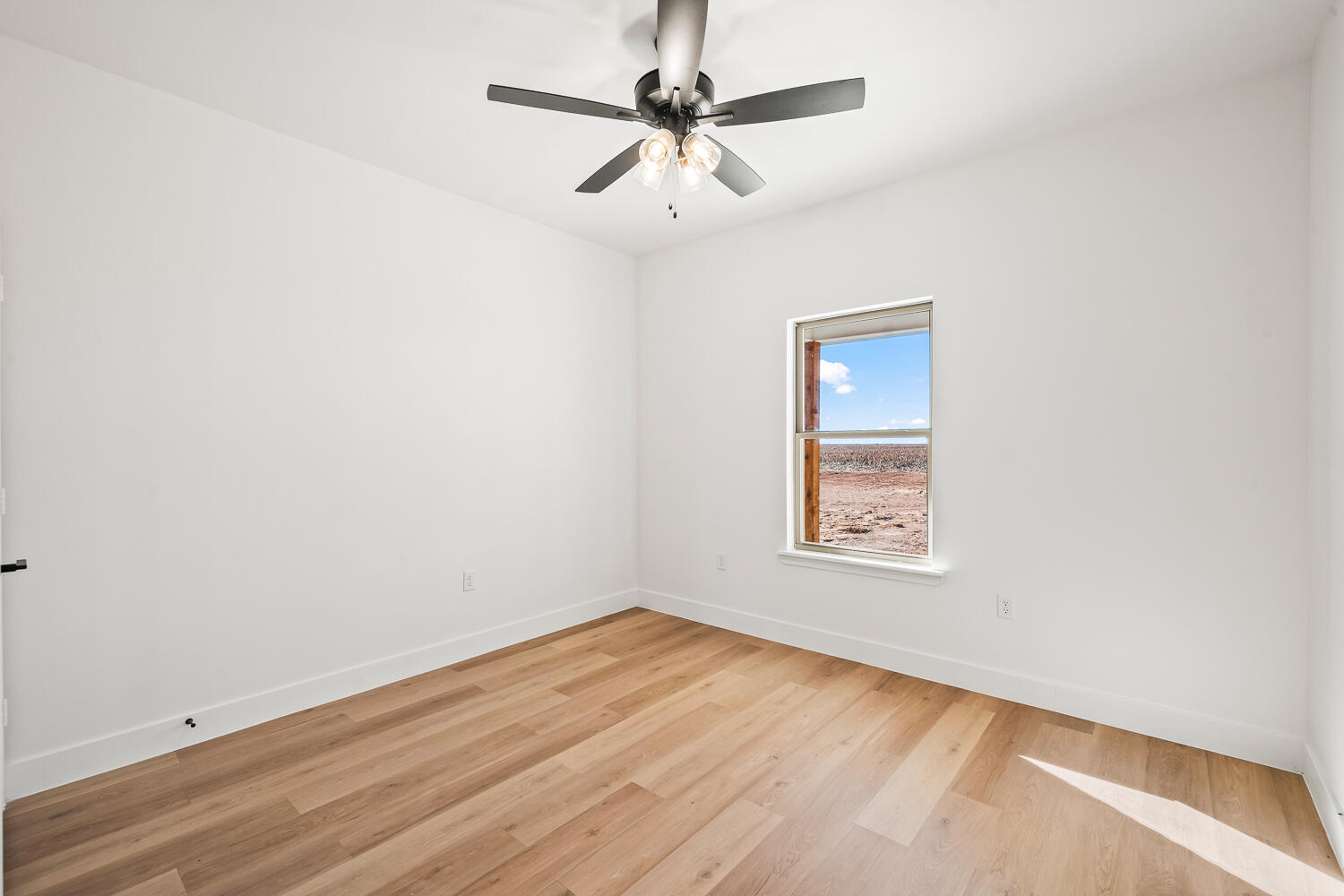 4062 Hawk Road Ropesville, TX 79358 - Photo 22 of 45 an empty room with a window and a ceiling fan