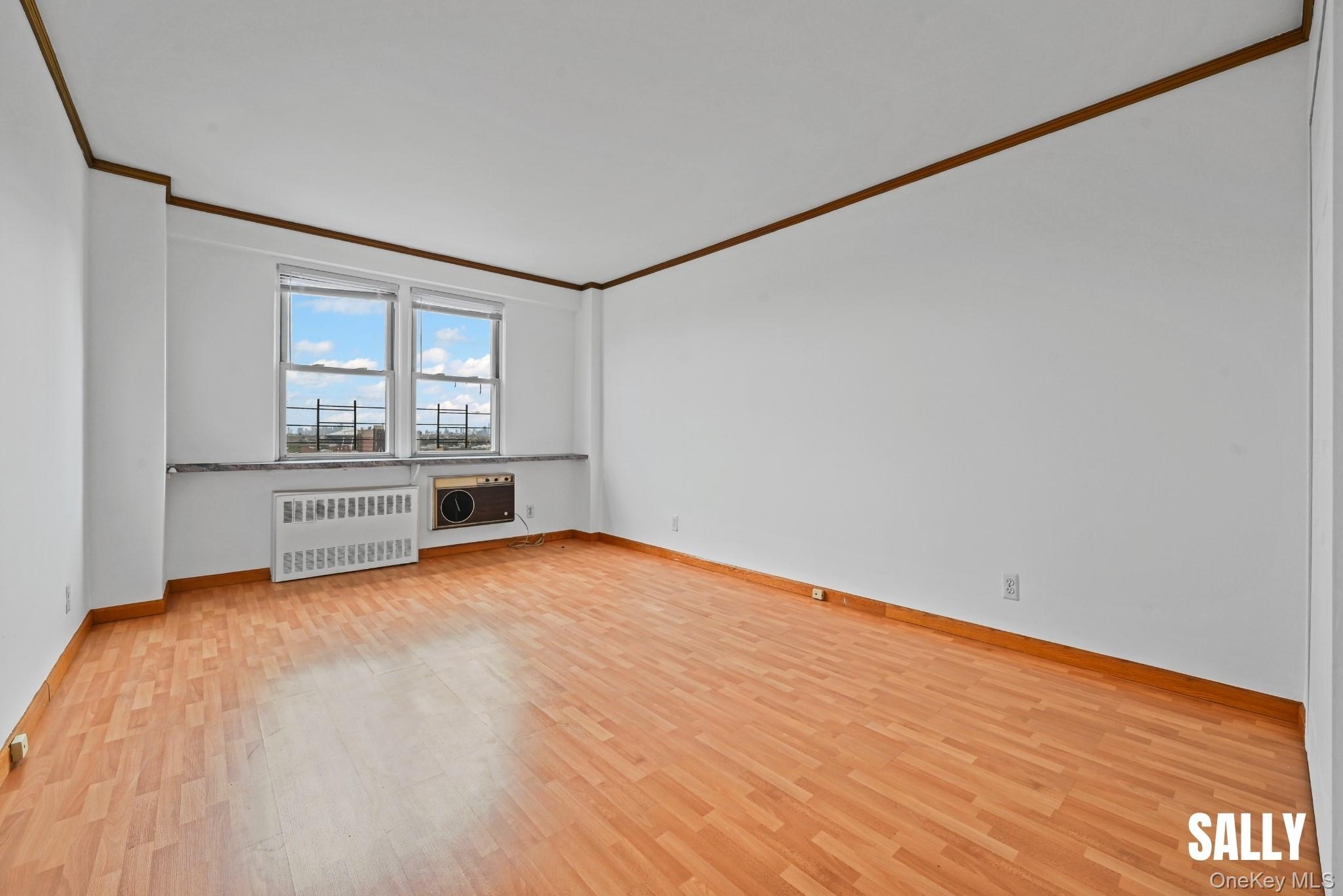 138-10 Franklin Avenue, Unit 12A Queens, NY 11355 - Photo 12 of 20 a view of an empty room with a window and wooden floor