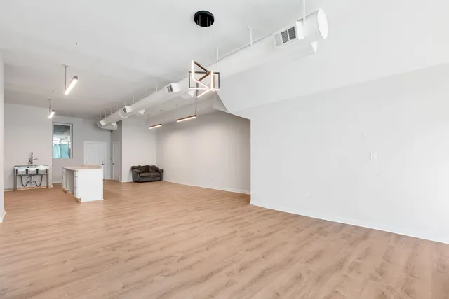 a view of a livingroom with a chair and wooden floor