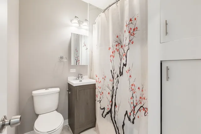 a bathroom with a toilet sink and shower curtain