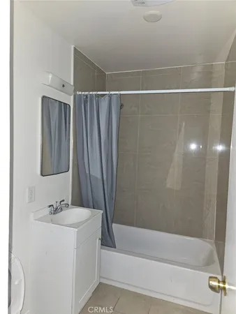 a bathroom with a granite countertop sink a mirror and a bathtub