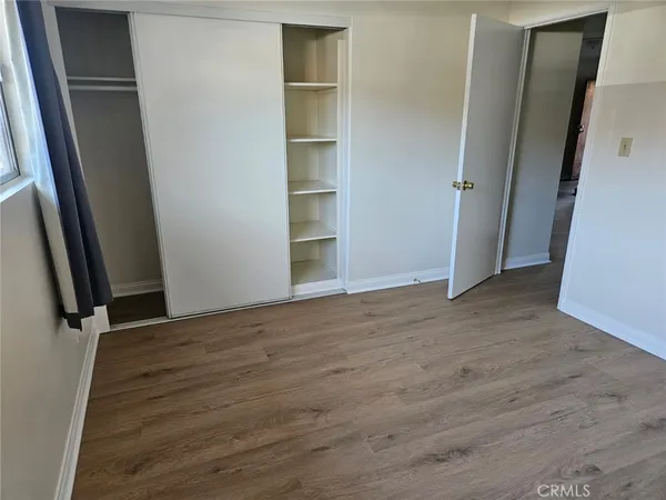 an empty room with wooden floor and closet