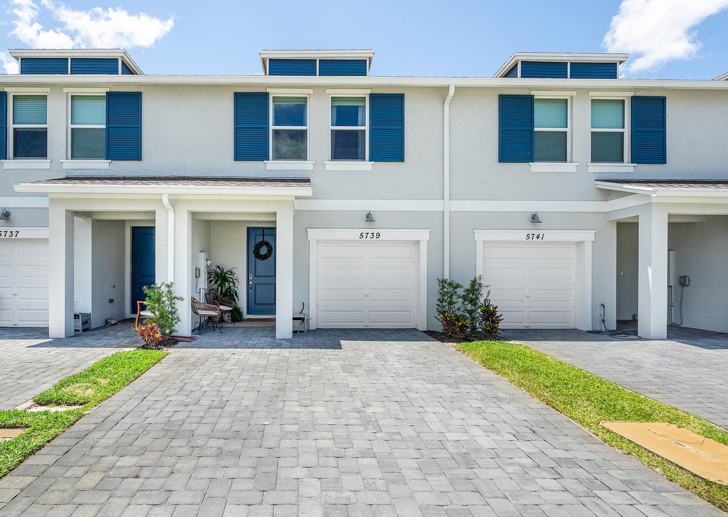 5739 Southeast Edgewater Circle Stuart, FL 34997 - Photo 28 of 29 a front view of a house with a yard and garage