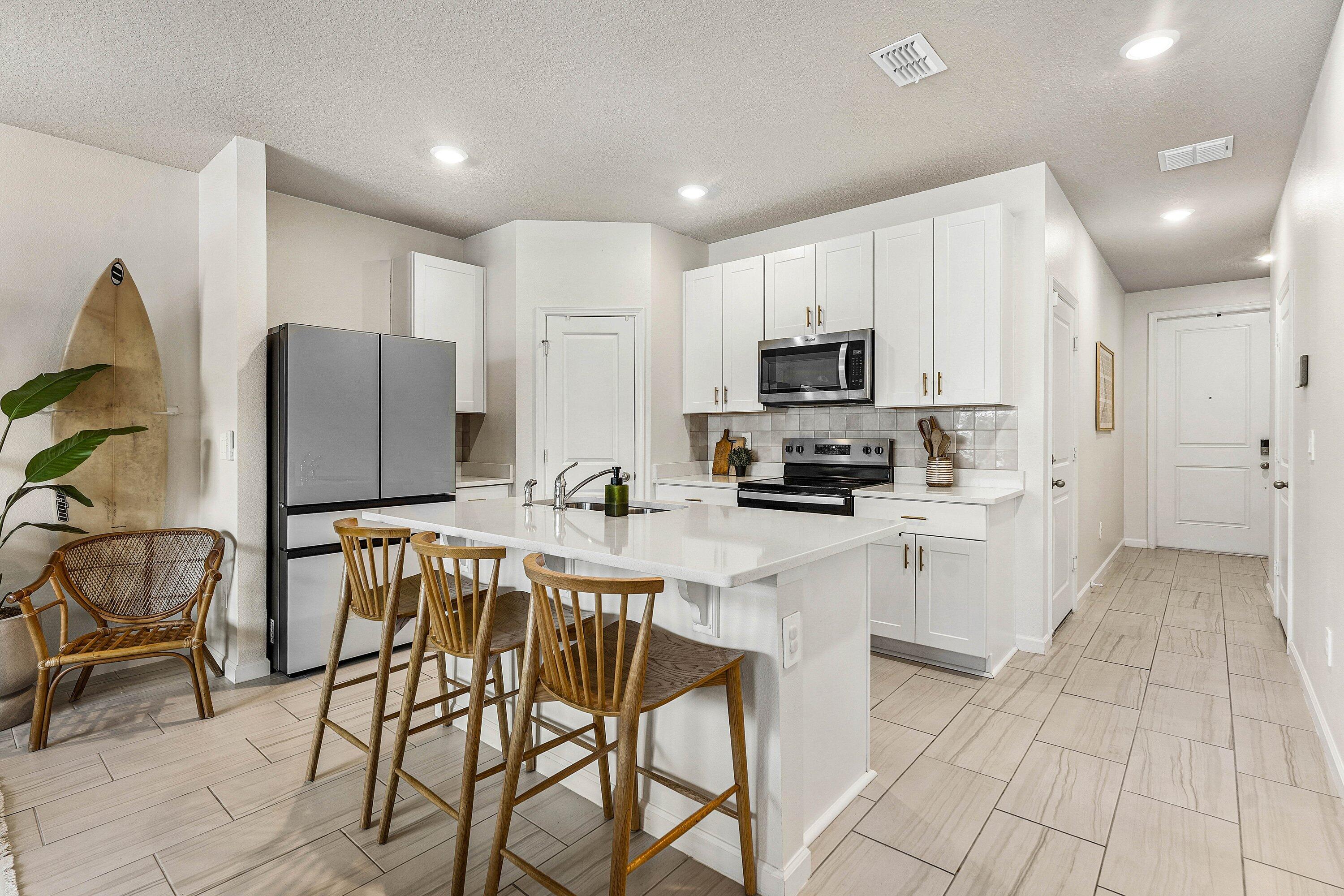 5739 Southeast Edgewater Circle Stuart, FL 34997 - Photo 5 of 29 a kitchen with stainless steel appliances granite countertop a stove a sink a refrigerator and a microwave
