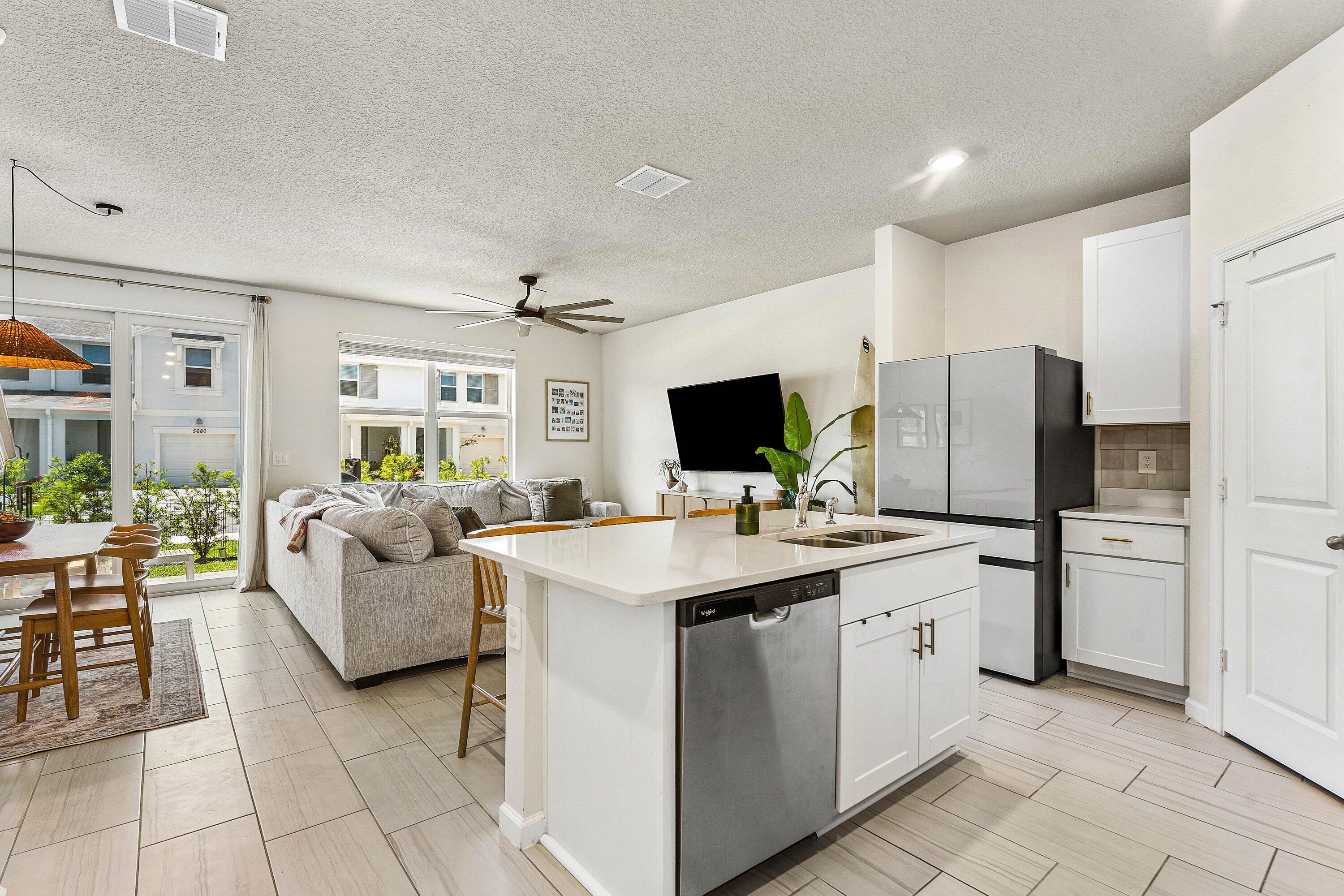 5739 Southeast Edgewater Circle Stuart, FL 34997 - Photo 8 of 29 a large white open kitchen with stainless steel appliances kitchen island granite countertop a sink and cabinets