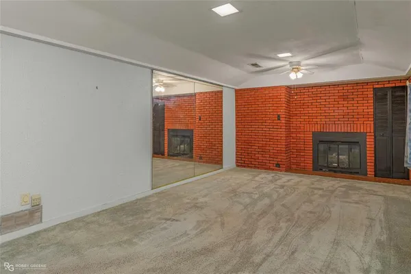 an empty room with cabinet and windows
