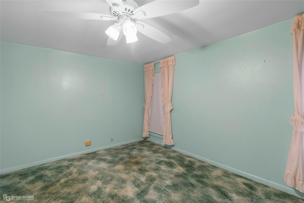 302 Princeton Road Princeton, LA 71067 - Photo 24 of 33 an empty room with a chandelier fan and windows