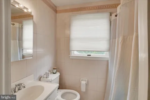 a bathroom with a toilet a sink and a mirror