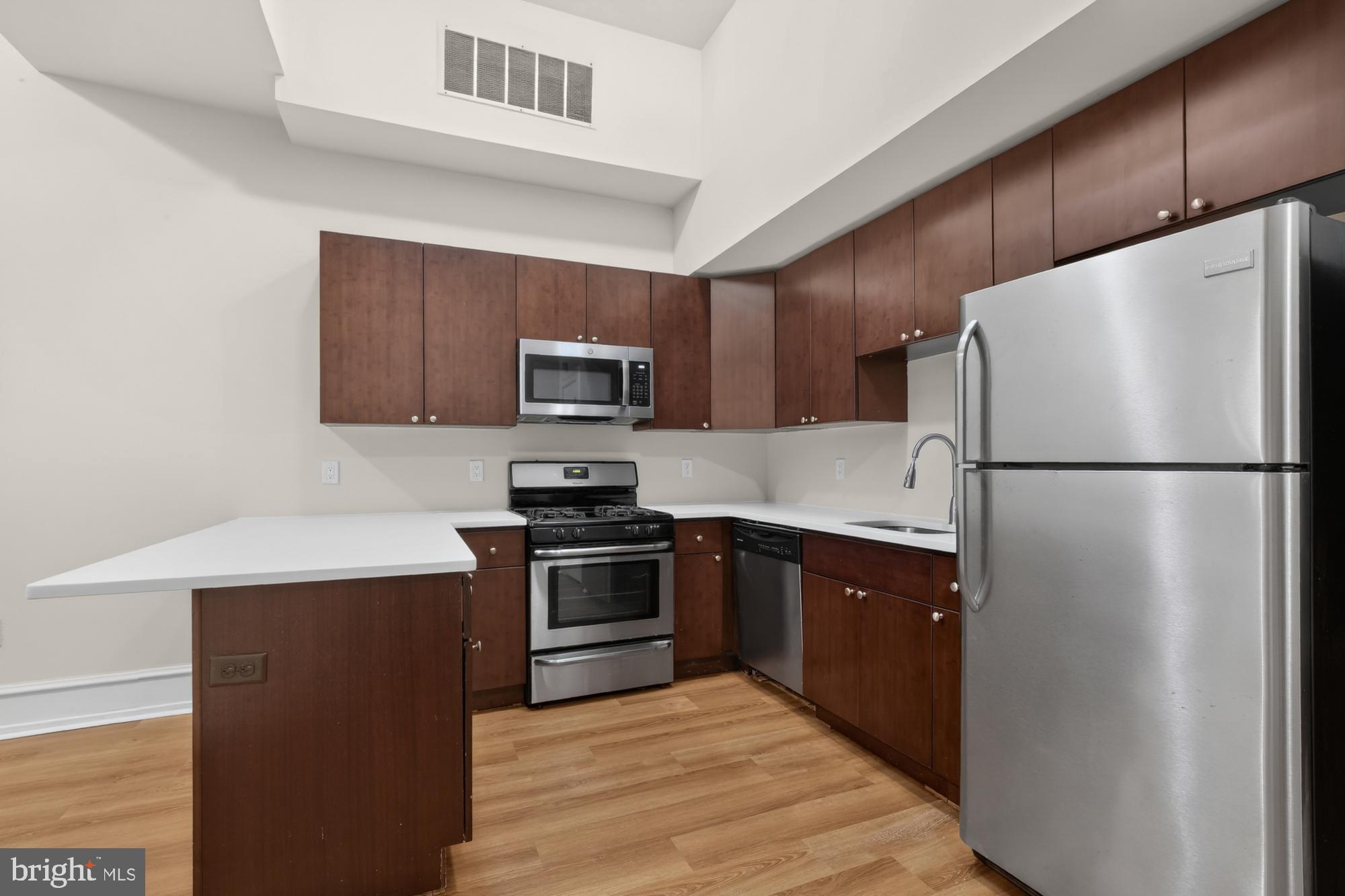 2136 East Dauphin Street, Unit 101 Philadelphia, PA 19125 - Photo 11 of 30 a kitchen with stainless steel appliances granite countertop a refrigerator stove a sink dishwasher and microwave