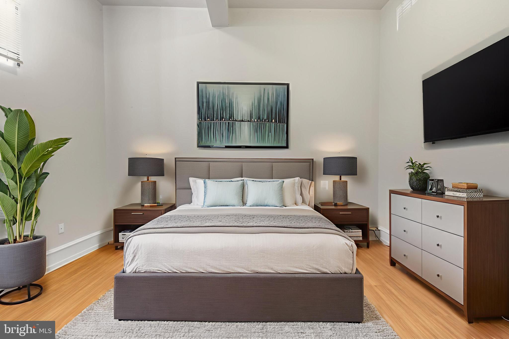 2136 East Dauphin Street, Unit 101 Philadelphia, PA 19125 - Photo 2 of 30 a bedroom with a bed and flat screen tv