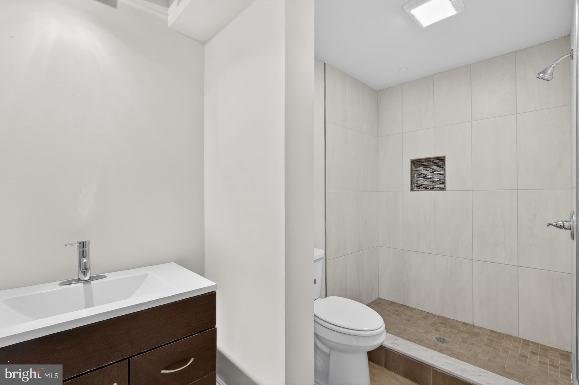 2136 East Dauphin Street, Unit 101 Philadelphia, PA 19125 - Photo 9 of 30 a bathroom with a sink a toilet and a mirror