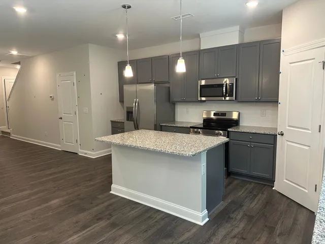 a kitchen with a sink a microwave a refrigerator and cabinets