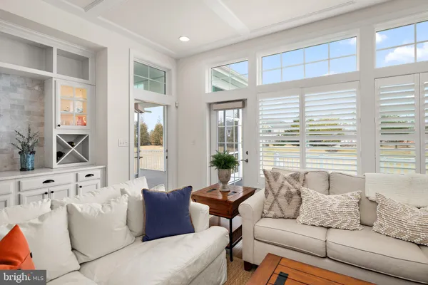 a living room with furniture and floor to ceiling windows