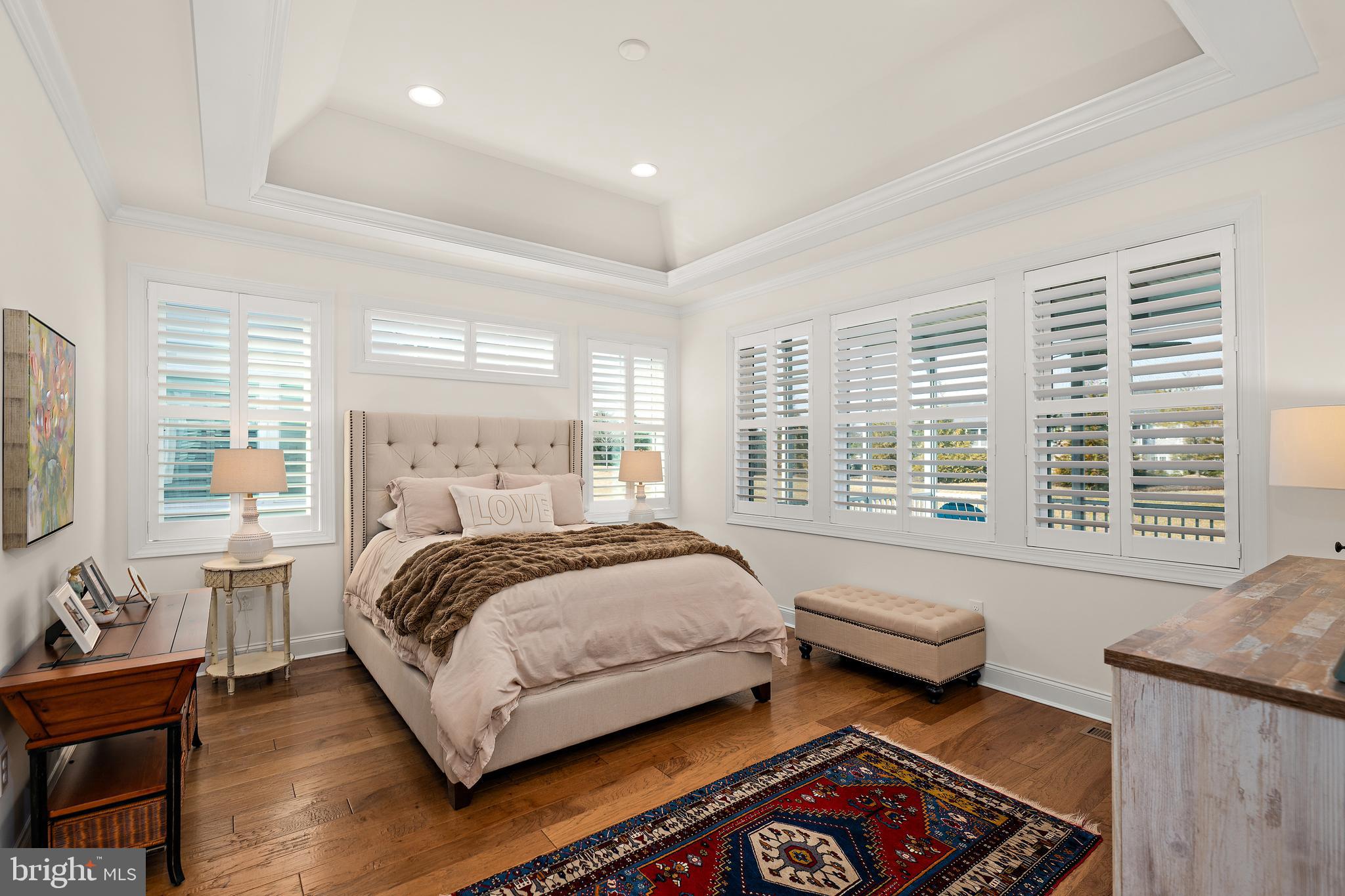 11119 Marvil Road, Unit 93 Lewes, DE 19958 - Photo 20 of 52 a spacious bedroom with a bed and wooden floor