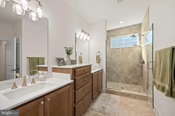 a bathroom with a double vanity sink mirror and shower
