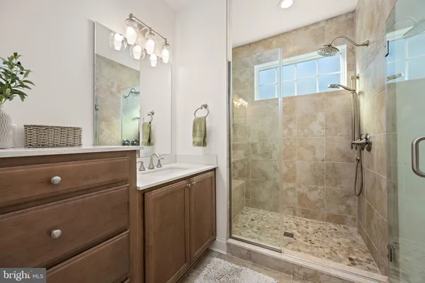 a bathroom with a shower sink and mirror