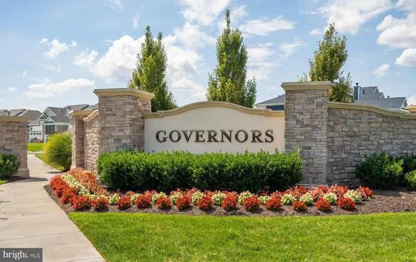 a view of a house with a big yard and large trees
