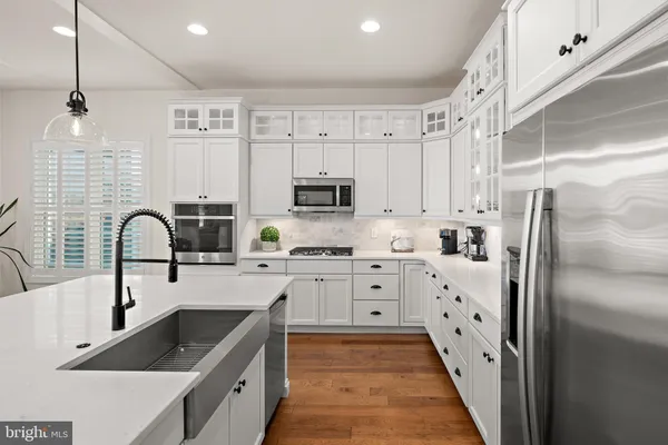 a kitchen with granite countertop a refrigerator sink and cabinets