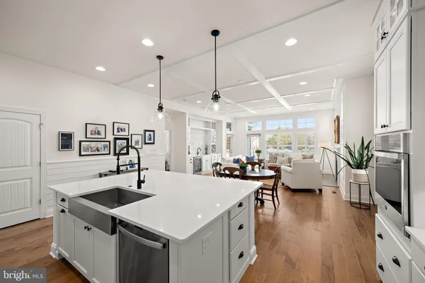 a kitchen with a stove a refrigerator a sink dishwasher with a dining table and chairs with wooden floor